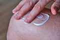 A man applies an anti-inflammatory healing cream to his leg with his hand. Treatment of arthrosis and arthritis, anti Royalty Free Stock Photo