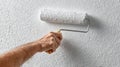 Man Rolls Fresh Paint Smoothly on Textured Wall During Home Improvement Project in Afternoon Light Royalty Free Stock Photo