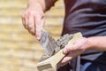 Man applies glue with spatula on decorative facing brick, view close up. Theme of construction