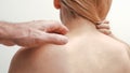 Man applying pain relieving cream, gel on woman's neck on white background. Pain relief and health care concept