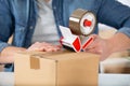 Man applying adhesive tape on packing box Royalty Free Stock Photo