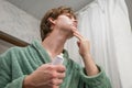 Man Applying Aftershave in Bathroom. Shaving Routine Royalty Free Stock Photo