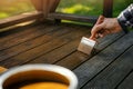 Applying brown wood protection oil on decking boards with paint brush. terrace renovation