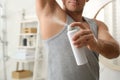 Man applying deodorant to armpit in bathroom, closeup Royalty Free Stock Photo