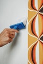 man applying glue to the wall with a pasting brush