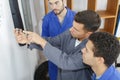 Man with apprentices holding bearing Royalty Free Stock Photo