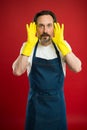 Man in apron with gloves cleaning agent. Cleaning day today. Bearded guy cleaning home. On guard of cleanliness and