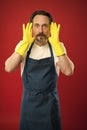 Man in apron with gloves cleaning agent. Cleaning day today. Bearded guy cleaning home. On guard of cleanliness and