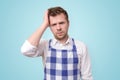 Man in apron having puzzled look going to make serious decision what to cook for dinner.