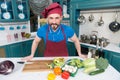 A Man in apron in the kitchen doing salad for vegans. Handsome man cooking at home preparing salad in kitchen. Handsome happy male