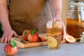 A man in an apron preparing a drink kombucha iced tea. Fermented probiotic refreshing kombucha or apple cider in a glass