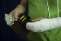 A man with an arm in a cast counted out money from the cost and expenses of emergency medical care at the hospital