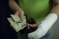 A man with an arm in a cast counted out money from the cost and expenses of emergency medical care at the hospital