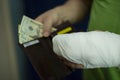 A man with an arm in a cast counted out money from the cost and expenses of emergency medical care at the hospital