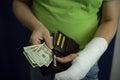 A man with an arm in a cast counted out money from the cost and expenses of emergency medical care at the hospital