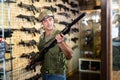 Man choosing rifle in airsoft shop