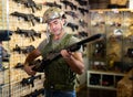 Man choosing rifle in airsoft shop