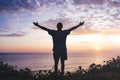 Man with arms outstretched celebrating in beautiful inspiring sunset