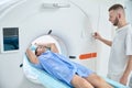 Radiographer is preparing adult patient for CT procedure