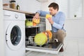 Man Arranging Dishes In Dishwasher Royalty Free Stock Photo