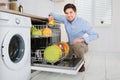 Man Arranging Dishes In Dishwasher Royalty Free Stock Photo