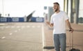 Man arriving at airport, waiting cab and using phone Royalty Free Stock Photo