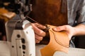 Man artisan sewing leather shoes indoors