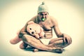 Man as baby. Child in diaper with pink teddy bear - retro style. Royalty Free Stock Photo