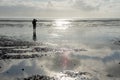 Man as a shilouette in the Wadden Sea of the North Sea in backlight and with reflection