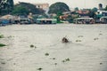 Man in asian conical hat is floating down Mekong river, Vietnam Royalty Free Stock Photo