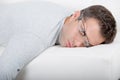 Man asleep on sofa glasses being pushed off face