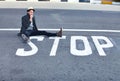 Man, asphalt and stop or sign on road, danger and sitting by symbol, bad habits and addiction to drugs. Male person Royalty Free Stock Photo