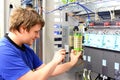 man assembles electronic components on a machine in a factory for mechanical engineering