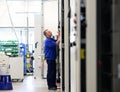 man assembles electronic components on a machine in a factory for mechanical engineering