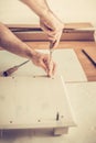 Man assembles furniture wardrobe, twists screws in the slots, furniture assembly