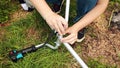 A man assembles the handle of string trimmer in the garden. Royalty Free Stock Photo