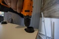 A man assembles a kitchen set. He holds a power drill, screwing the tool into a white cabinet, symbolizing home improvement, DIY Royalty Free Stock Photo