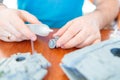 A man assembles a model of a toy tank from plastic, glues a hatch from a tank with an installed machine gun Royalty Free Stock Photo