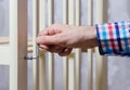 A man assembles a white wooden crib, screws in euro bolts with a hex key