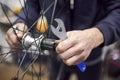 Man assembling a bike wheel axle as part of a bicycle maintenance service