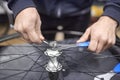 Man assembling a bike wheel axle as part of a bicycle maintenance service Royalty Free Stock Photo