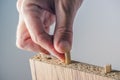 Man assembling furniture at home, hand with wooden dowel pins