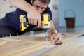 Man assembling furniture at home using a cordless screwdriver