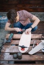 Man assembling skateboard and adding wheels outdoor