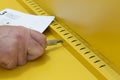 Man assembling a yellow metal cabinet with a screwdriver and instructions. Self assembly furniture concept