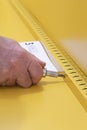 Man assembling a yellow metal cabinet with a screwdriver and instructions. Self assembly furniture concept