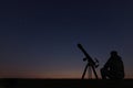 Man with astronomy telescope looking at the stars.