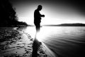 Man checking time during workout run exercise outdoors at ocean beach in sunny cold morning. Runner in sportswear