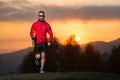 Man athlete practicing nordic walking in the mountains at sunset Royalty Free Stock Photo