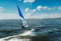 The man athlete rides the windsurf over the waves on lake